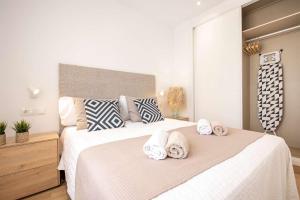 a bedroom with two beds with towels on them at APARTAMENTOS CARMEN in Maro