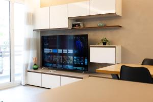 uma sala de estar com uma televisão grande e uma mesa em Wonderful Apartament, Near The Lake em Lugano