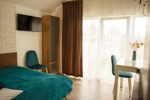 una camera d'albergo con letto, scrivania e finestra di Комплекс На Дачі a Vyshpolʼ