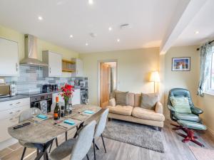 a kitchen and living room with a table and a couch at The Stables in Forden