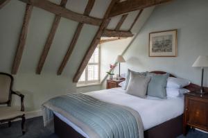 a bedroom with a large bed and a chair at Chilston Park Hotel in Maidstone