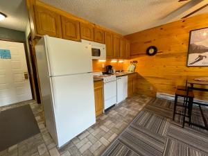 a kitchen with a white refrigerator and a table at Relax, Adventure, Views, Amenities+Memories (Full) in Granby