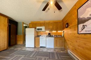a kitchen with a white refrigerator and wooden cabinets at Relax, Adventure, Views, Amenities+Memories (Full) in Granby