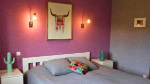 a bedroom with a bed with purple walls at Villa les Rosiers in Tallard