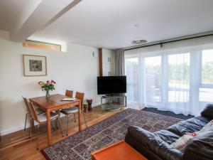 a living room with a table and a couch at Plum Hill Apartment in Oswestry