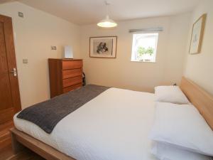 a bedroom with a large white bed and a window at Plum Hill Apartment in Oswestry