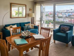 a living room with a table and a blue couch at 3 Linden Court in Brixham