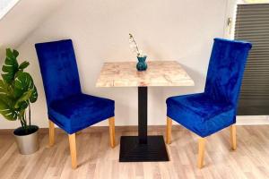 Dos sillas azules y una mesa con un jarrón. en Zuhause im Ruhrgebiet 3 mit Balkon, en Oberhausen