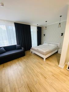 um quarto grande com uma cama e um sofá em Sunny apartment в ЖК Сонячний Квартал em Golubinoye