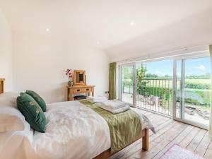 a bedroom with a large bed and a balcony at Dragonfly Den - Uk44530 in Horncastle