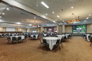a banquet hall with tables and chairs and a screen at Stoney Creek Hotel Columbia in Columbia