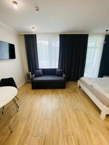 um quarto com uma cama, um sofá e uma mesa em Sunny apartment в ЖК Сонячний Квартал em Golubinoye