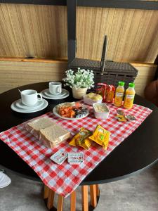 una mesa con comida en un paño de mesa blanco y rojo en Chales Naturale - Campos do Jordão - CNA, en Campos do Jordão