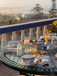 uma mesa com pratos, copos e bebidas em Villa Maroc Essaouira em Essaouira