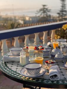 einen Tisch mit Tellern und Tassen und Getränken darauf in der Unterkunft Villa Maroc Essaouira in Essaouira