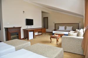 a hotel room with two beds and a television at West Davraz Hotel in Cobanisa