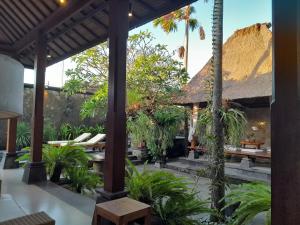 a resort with a patio with tables and palm trees at Tropical Retreat Villa in Gianyar