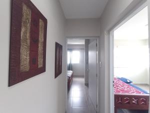 ein Flur mit einem Zimmer mit einem Bett und Gemälden an der Wand in der Unterkunft El Bienestar. in San Salvador de Jujuy + 5 Fotos