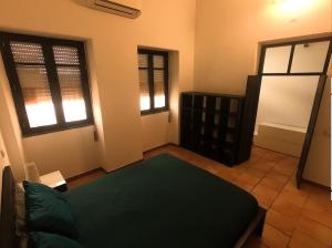 sala de estar con 1 cama verde y 2 ventanas en Casa na Vila T2 en Fuzeta