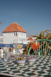uma mesa com dois copos de vinho e taças de comida em Villa Maroc Essaouira em Essaouira