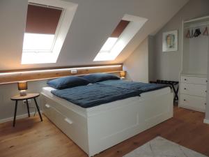 a bedroom with a large white bed and two skylights at Ferienwohnung-Geltendorf Nähe Ammersee in Geltendorf