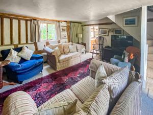 a large living room with couches and a tv at Thatched Cottage in Saxmundham