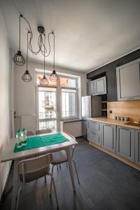a kitchen with a table and chairs and a table and a kitchen with at Vistula River Modern Apartment in Krakow