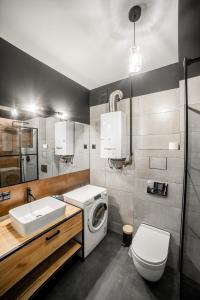 a bathroom with a washing machine and a sink at Vistula River Modern Apartment in Krakow