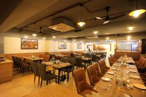 a dining room with tables and chairs in a restaurant at Hotel Dolphin Grand in Varanasi