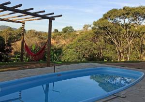 - une piscine avec un hamac et une vue sur les montagnes dans l'établissement Chácara Santa Luzia, à Socorro