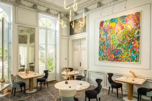 un restaurant avec des tables et des chaises et une peinture murale. dans l'établissement Clarance Hotel Lille, à Lille