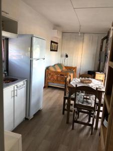 a small kitchen with a table and a refrigerator at DARMI in Villa Serrana