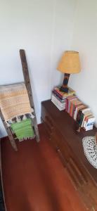 a room with a chair and a lamp and books at DARMI in Villa Serrana