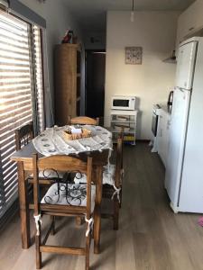 eine Küche mit einem Tisch und Stühlen sowie einem Kühlschrank in der Unterkunft DARMI in Villa Serrana