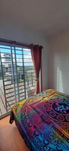 ein Schlafzimmer mit einem Bett und einem großen Fenster in der Unterkunft DARMI in Villa Serrana