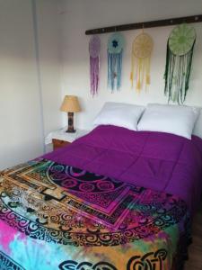 a bedroom with a bed with a purple comforter at DARMI in Villa Serrana