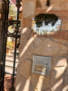 ein Schild an einer Steinmauer mit einem Lüftungsschacht in der Unterkunft Villa Regina Accommodation in Santa Domenica