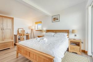 1 dormitorio con 1 cama grande con sábanas blancas en The Bay, en Culnacnoc