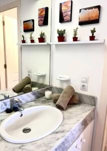 a bathroom with a sink and a mirror at Stunning sunset ocean view apt. in Taurito