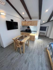 ein Wohnzimmer mit einem Holztisch und einem TV in der Unterkunft Casa del Caffè Boutique in Triest