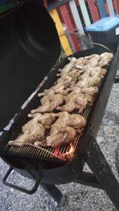 un montón de pollos cocinando en una parrilla en Rancho el novato, en Concepción de La Vega