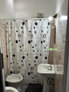 a bathroom with a toilet and a sink and a shower curtain at Los Cactus in La Rioja
