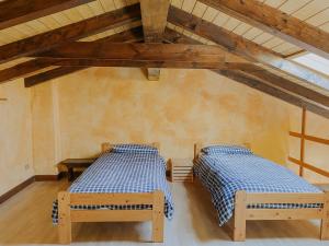 two beds in a room with wooden ceilings at Ca’ Ai Monti in Trarego