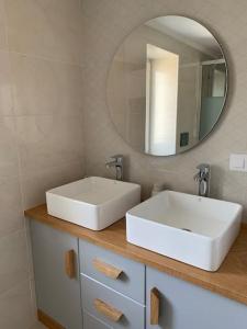 een badkamer met 2 witte wastafels en een spiegel bij A de Féliz Ribadeo in Ribadeo