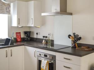 a kitchen with white cabinets and a stove top oven at Home Choi in Culloden