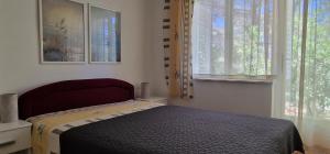Schlafzimmer mit einem Bett und einem Fenster in der Unterkunft Apartment Park in Šilo