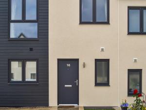 a house with a black door and windows at Home Choi in Culloden