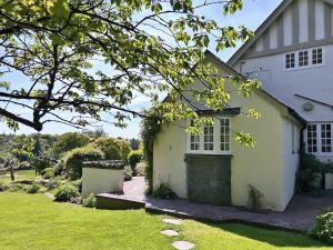 a white house with a window and a yard at Overwater Lodge in Bassenthwaite Lake