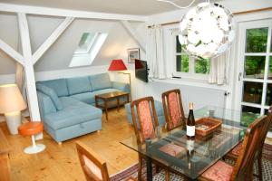 a living room with a blue couch and a glass table at Rosi's Ferienwohnung im Haus Sieglinde in Prien am Chiemsee