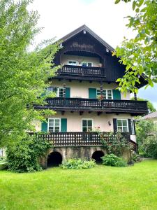 a building with a balcony on top of a yard at Rosi's Ferienwohnung im Haus Sieglinde in Prien am Chiemsee